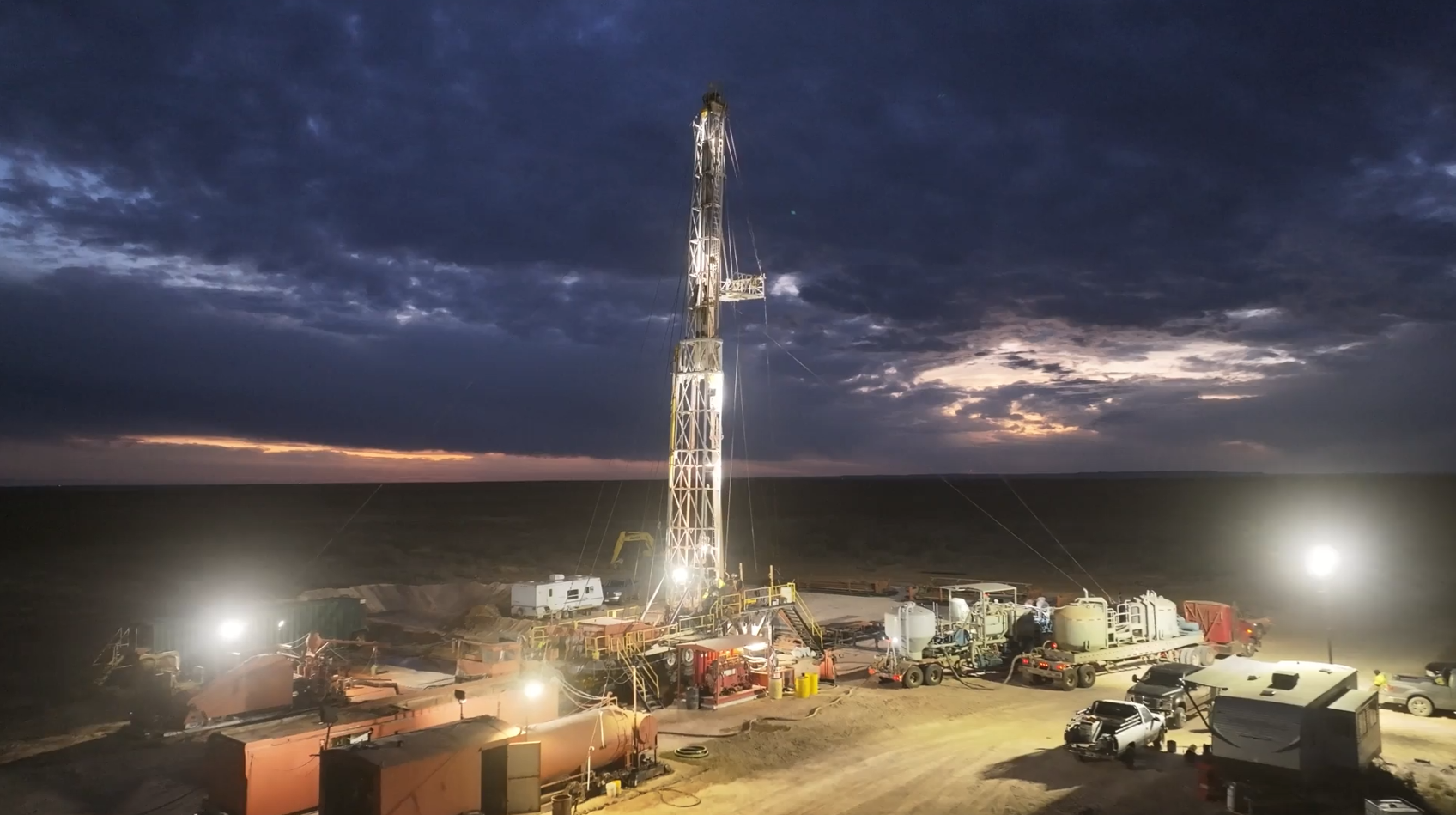 Rise Drilling rig lit up at dusk on a Texas drilling location